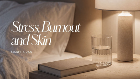 Warm bedside scene with a glass of water, a closed book, and a softly lit lamp on a stone nightstand